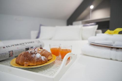 um prato com um produto de pastelaria e um copo de sumo de laranja em B&B Milleduecento Luxury Room em Salerno