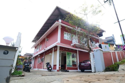 un edificio rojo con una motocicleta estacionada frente a él en Hillside Hideaway Gudalur, en Gūdalūr