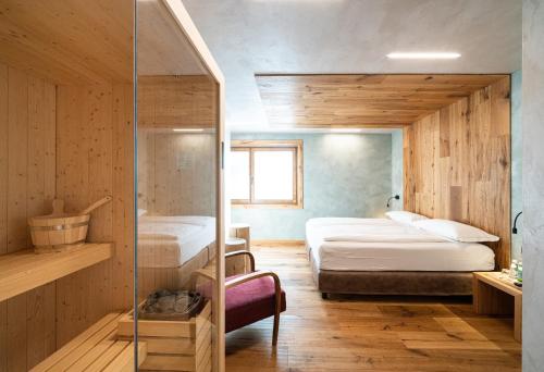 1 dormitorio con 2 camas y ducha a ras de suelo en Hotel Larice, en Livigno