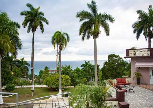 einen Blick auf das Meer von einem Haus mit Palmen in der Unterkunft Bella Vista Vacation in Montego Bay