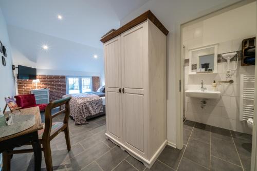 une salle de bains avec un placard et un lavabo et une salle de bains avec une chambre. dans l'établissement INSEL-LAND-HOTEL MICHAELSEN im Ostland, à Borkum