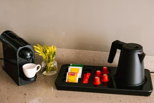 una macchinetta del caffè nera seduta su un bancone della cucina di Sonder Business Bay a Dubai