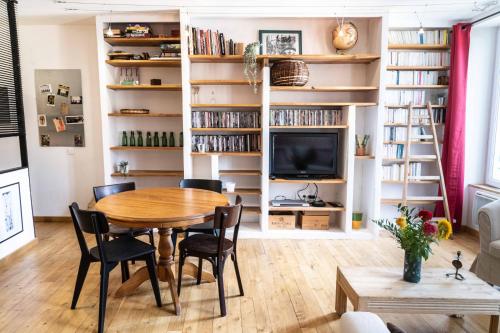 uma sala de jantar com mesa, cadeiras e estantes em Calme et confort en coeur de ville em Draguignan