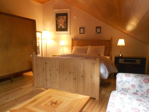 een slaapkamer met een houten bed met 2 lampen en een bank bij Sintra Small Hostel in Sintra