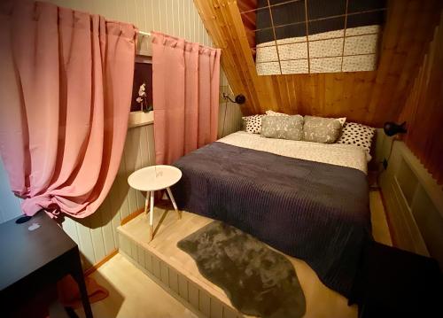 a small bedroom with a bed and a table at Amazing little house on an island with garden in Rīga