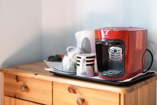 a red toaster sitting on top of a wooden cabinet at Pension Primavera in Vienna