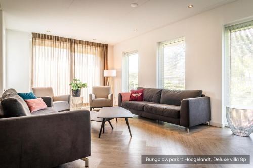 ein Wohnzimmer mit 2 Sofas und einem Tisch in der Unterkunft Bungalowpark 't Hoogelandt in De Koog