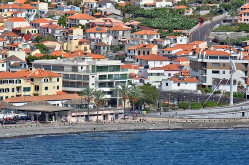 uma vista para uma cidade com casas e a água em Machico Beach, a Home in Madeira em Machico