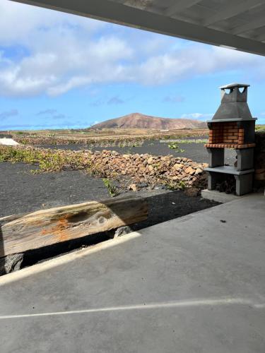 um pedaço de madeira sentado ao lado de um forno de tijolos em El Cercado em Tinajo