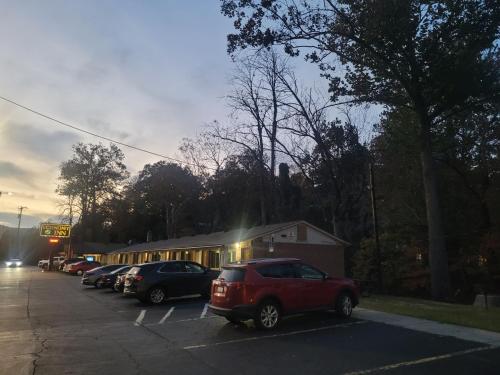 un parking avec des voitures garées devant un bâtiment dans l'établissement Economy Inn Sylva, à Sylva