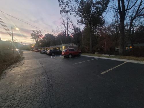 un parking avec des voitures garées à côté d'un bâtiment dans l'établissement Economy Inn Sylva, à Sylva