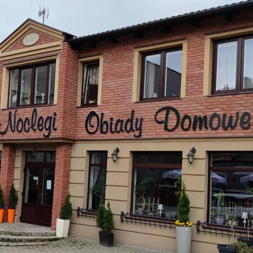 un bâtiment avec un panneau indiquant l'ovation d'OUley dans l'établissement Hotelik Kościerzyna, à Kościerzyna