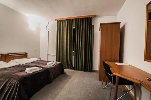 a hotel room with a bed and a desk and a desk at YETI-clubcom in Gudauri