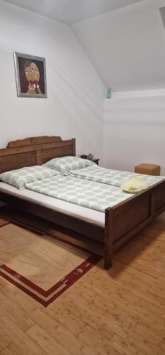 een groot bed in een kamer met een houten frame bij Smještaj Slavonija in Daruvar