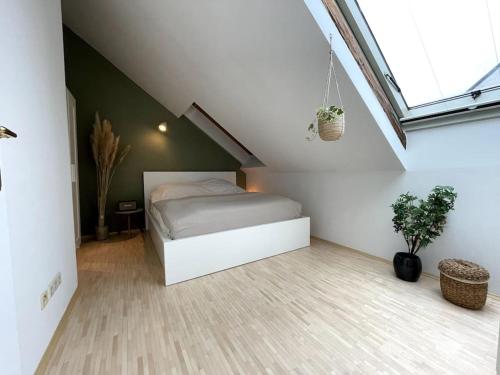 1 dormitorio con 1 cama blanca en el ático en Helles Apartment im Zentrum, en Graz