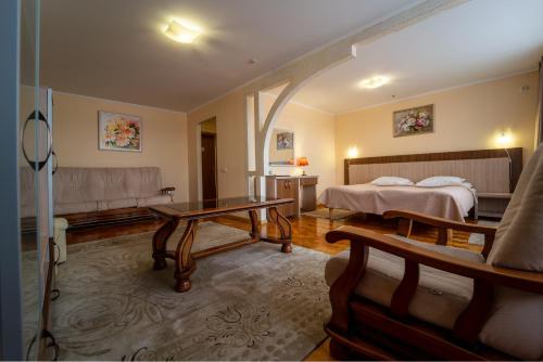 a hotel room with a bed and a table at Hotel Halychyna in Ternopilʼ