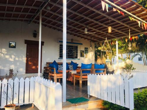 une maison avec une clôture blanche, une table et des chaises dans l'établissement West Valley Farm Villa, à Lavasa