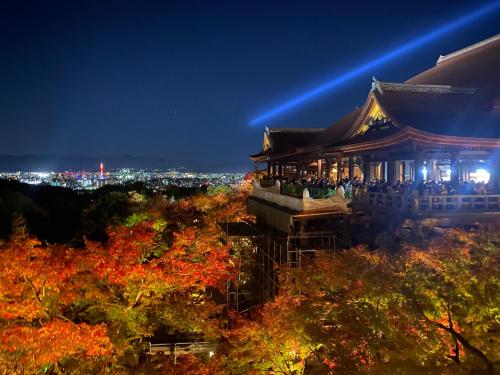 um edifício chinês à noite com uma cidade ao fundo em Hanakiya em Quioto