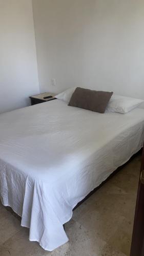 uma cama branca num quarto com uma colcha branca em Hotel fresno Xochitepec em Chiconcuac