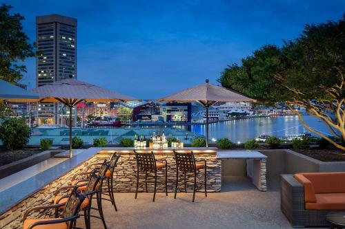 un patio con sillas y un bar con vistas al agua en Hyatt Regency Baltimore, en Baltimore