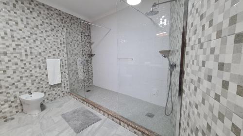 y baño blanco con ducha y aseo. en Santa Luzia Apt I, en Ribeira Grande