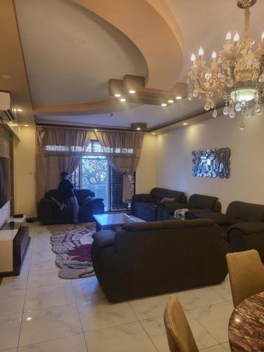 a living room with couches and a chandelier at Meshaal heights in Mombasa