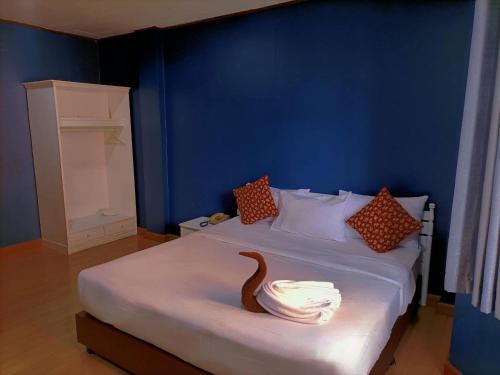 een blauwe slaapkamer met een bed met een houten slang erop bij Rimtarn Hotel Pakchong in Pak Chong