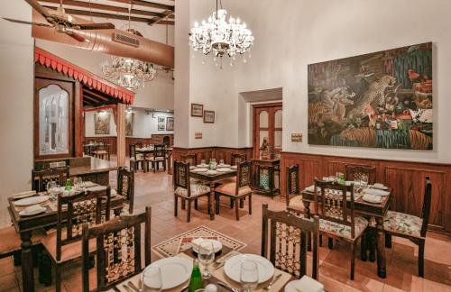 een restaurant met tafels en stoelen en een schilderij aan de muur bij Storii By ITC Hotels, Shanti Morada Goa in Calangute