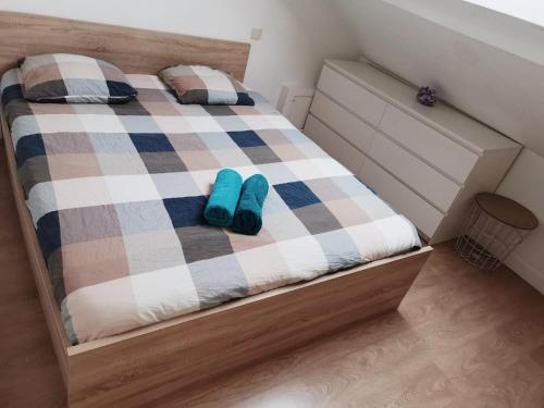 een slaapkamer met een bed met blauwe schoenen erop bij SW Cosy Apart - Chambly Persan Roissy in Persan