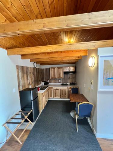 a kitchen with wooden ceilings and a table and a refrigerator at Garden of the Gods Motel in Colorado Springs