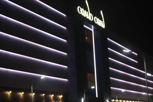 un'insegna al neon sul lato di un edificio di AZ Hotels Grand Oran a Orano