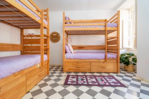 2 stapelbedden in een kamer met een geruite vloer bij Female Hostel in Faro