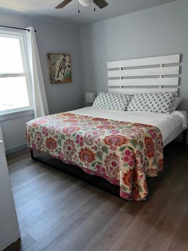 um quarto com uma cama grande e uma colcha floral em Guesthouse Cannon Beach em Cannon Beach