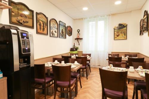 a restaurant with tables and chairs in a room at Hôtel Gloria in Grenoble