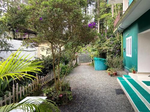 a garden with a fence and a tree at Ammus Homestay in Thekkady