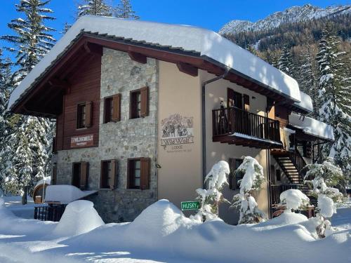 a building covered in snow with snow covered trees at WILDHOMES Wild Wolf Lodge in Courmayeur