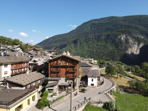 ein Dorf mit einer Straße vor einem Berg in der Unterkunft Albergo Le Marmotte in Pré-Saint-Didier