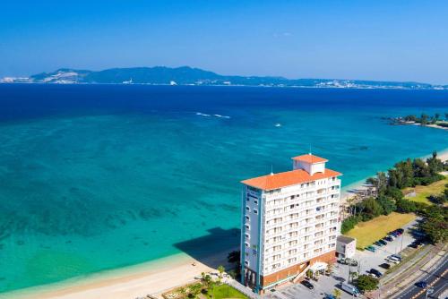 eine Luftansicht eines Gebäudes neben dem Meer in der Unterkunft Best Western Okinawa Kouki Beach in Nago