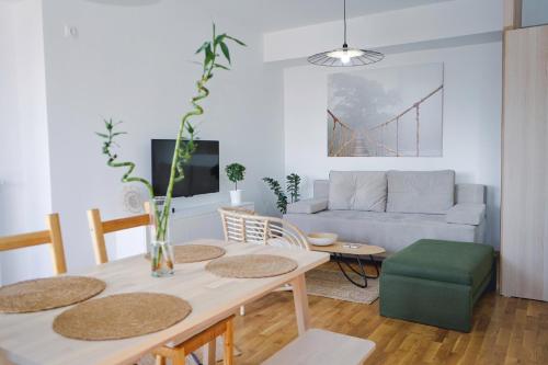 een woonkamer met een tafel en een bank bij Sunlight Apartment in Skopje