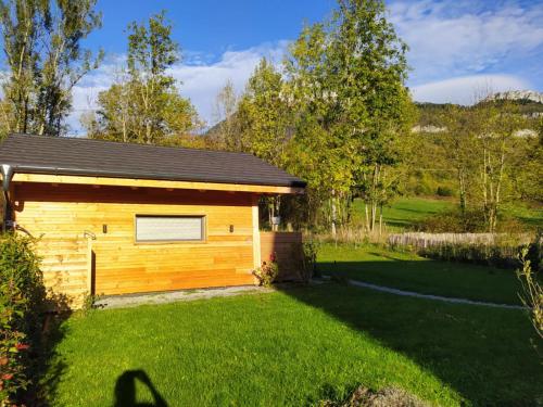 een kleine houten hut met een grasveld bij Maisonnette in Talloires