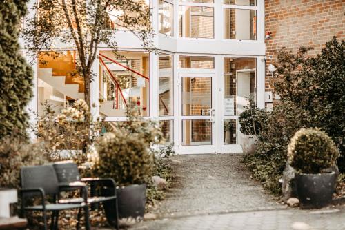 une passerelle menant à un bâtiment avec porte dans l'établissement Akzent Hotel Zur Grünen Eiche, à Bispingen