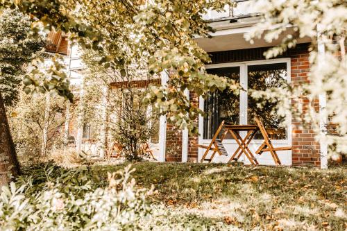 une terrasse couverte à l'avant d'une maison avec un banc en bois dans l'établissement Akzent Hotel Zur Grünen Eiche, à Bispingen