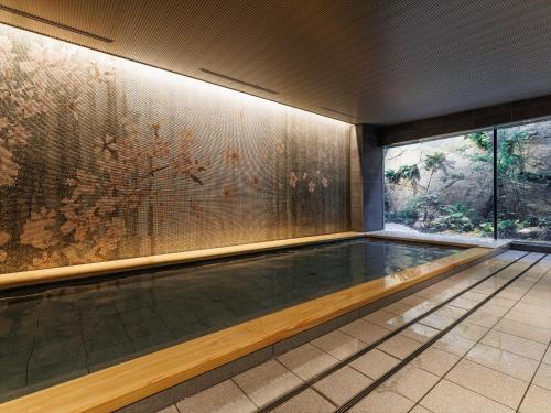 - une piscine dans un bâtiment orné d'une peinture murale dans l'établissement THE BLOSSOM KYOTO, à Kyoto