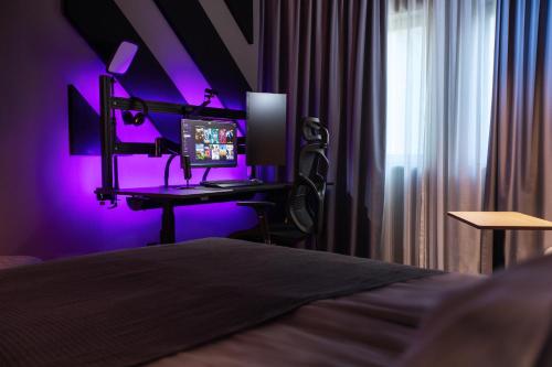 - une chambre avec un bureau, un ordinateur et une lumière violette dans l'établissement Quality Hotel Globe, à Stockholm