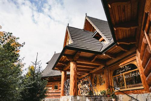 uma cabana de madeira com um telhado de gambrel em Zakopiański Dwór em Zakopane