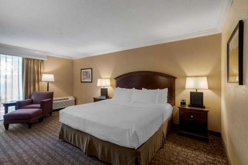 a hotel room with a large bed and a chair at Best Western Inn of the Ozarks in Eureka Springs