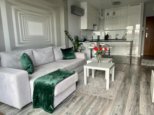 uma sala de estar com um sofá e uma mesa em Apartament Winnica em Toruń