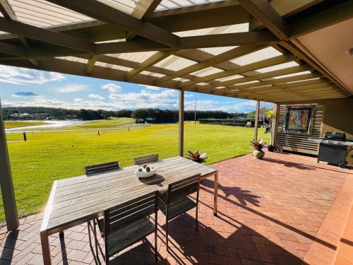 einen Picknicktisch auf einer Terrasse mit Blick auf ein Feld in der Unterkunft Perfect weekend getaway plus golf at your doorstep in Salamander Bay