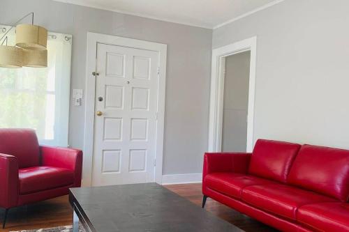 - un salon avec deux canapés rouges et une table dans l'établissement Spanish Town / Downtown Apartment, à Bâton-Rouge