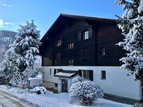 シャルメにあるAppartement 53m2 rénové dans un chalet au coeur de Charmey avec vue sur les montagnesの雪に覆われた建物